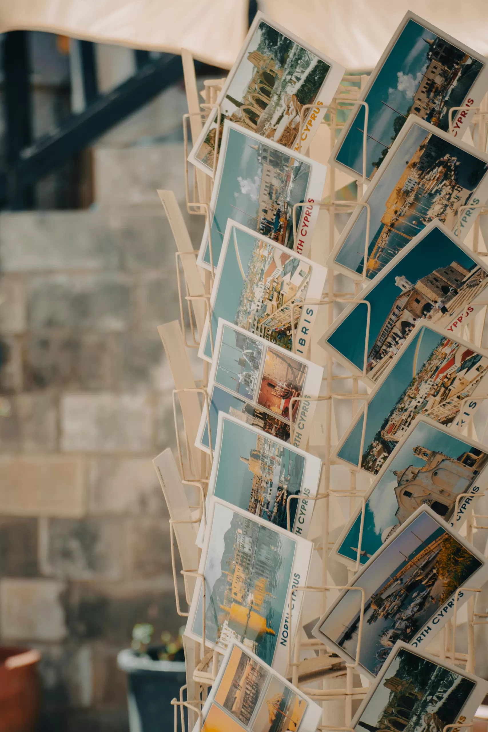 Vibrant collection of seaside postcards displayed on a rack showcasing coastal landscapes.